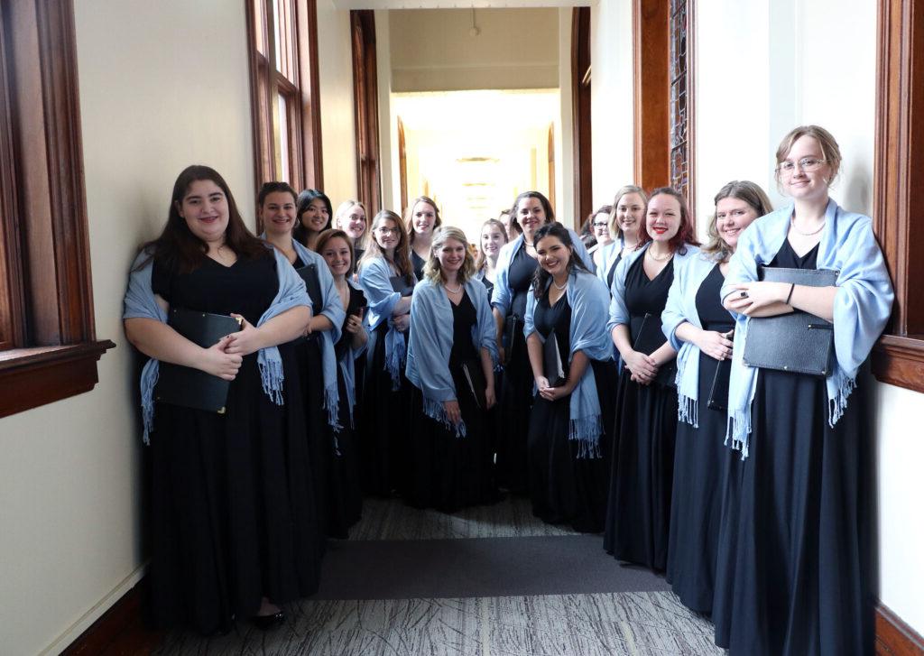 Choir students smile for a group picture before a concert